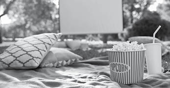 Popcorn and drink on blanket in open air cinema  Space for text