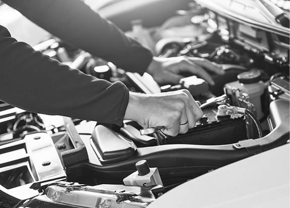 Hands of car mechanic with wrench in garage