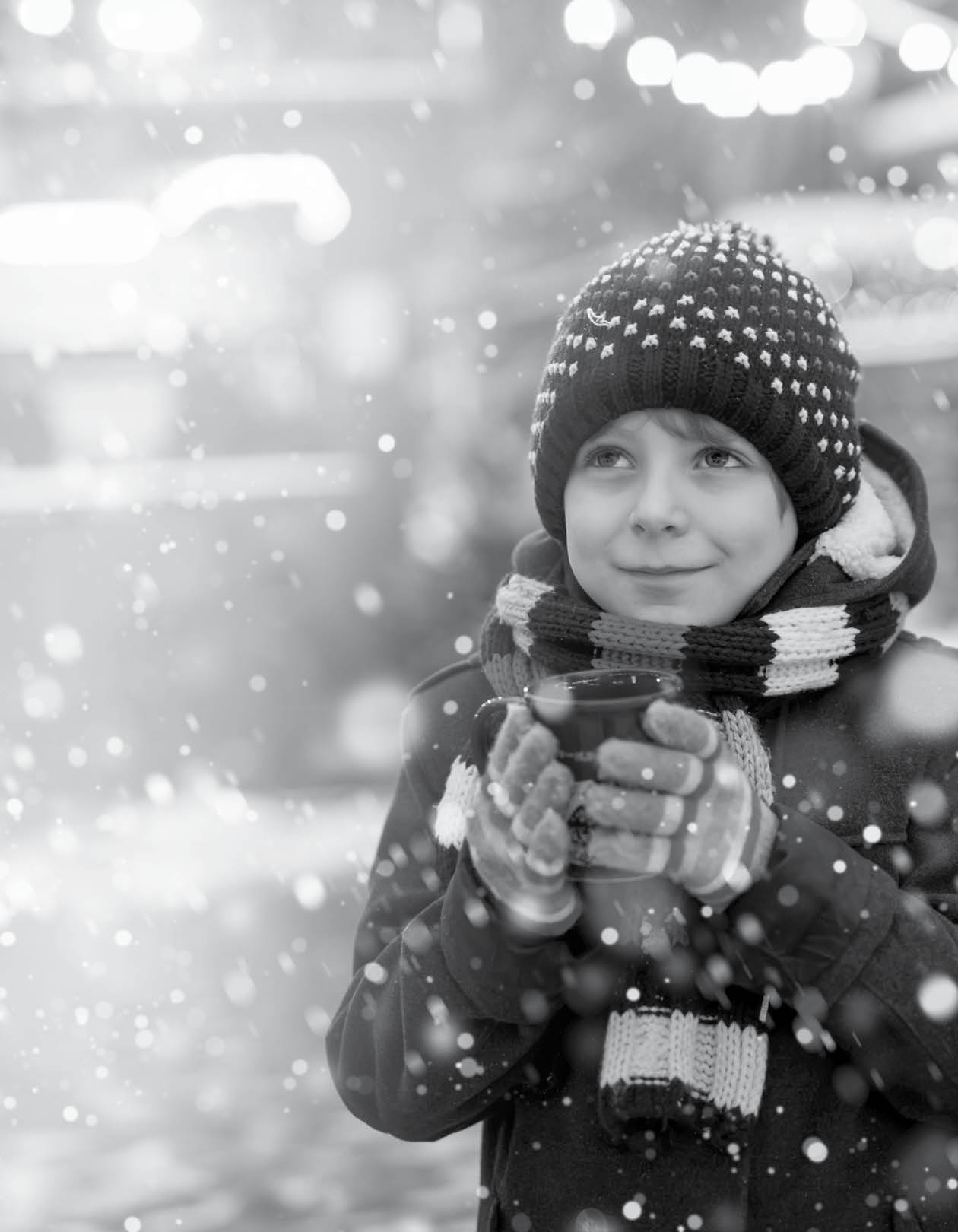 Little cute kid boy drinking hot children punch or chocolate on German Christmas market. Happy child on traditional family market in Germany, Laughing boy in colorful winter clothes