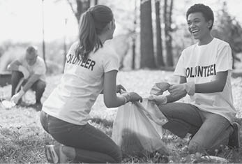 Green volunteering. Optimistic two volunteers holding garbage bag and communicating