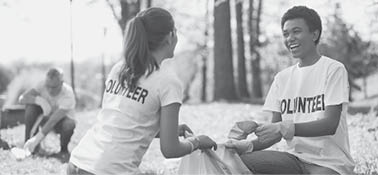 Green volunteering. Optimistic two volunteers holding garbage bag and communicating