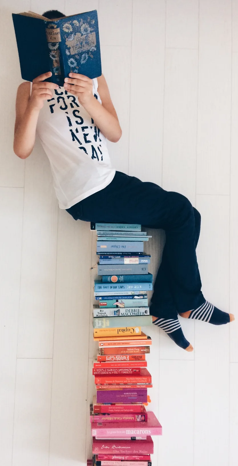 person sitting on a pile of books